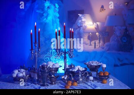 Table setting with candles, marshmallows and tangerines. Holidays, catering and hospitality concept. Stock Photo