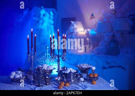Table setting with candles, marshmallows and tangerines. Holidays, catering and hospitality concept. Stock Photo