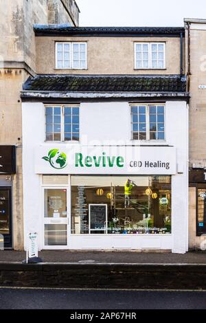 A recently opened shop specialising in the sale of CBD products with a workman on scaffolding the opposite side of the road reflected in the window Stock Photo