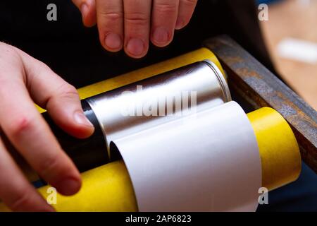 manual application of stickers on aerosol cans with automotive and other chemical composition Stock Photo