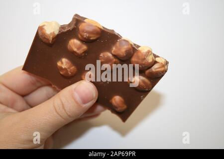 Chocolate with whole hazelnuts in hand Stock Photo