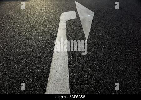 Close up of isolated white arrow on asphalt road showing right direction - Germany Stock Photo