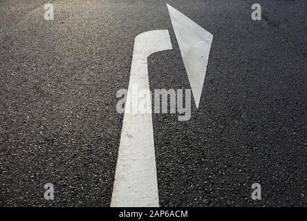Close up of isolated white arrow on asphalt road showing right direction - Germany Stock Photo