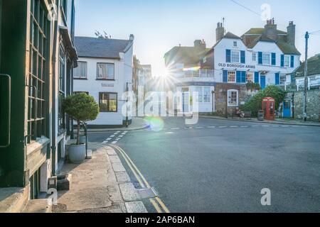 Rye England - August 20 2019; Old Borough Arm and Mermaid Cafe building on corner Mermaid Street and the Strand as sun bursts through between building Stock Photo