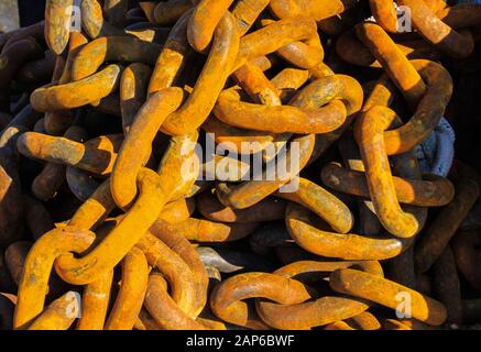 Full frame close up of bunch old rusty brown anchor chain links in natural sun light Stock Photo