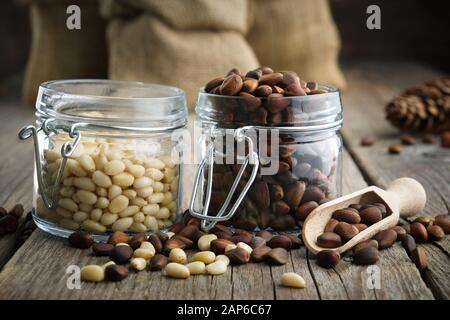 Pine nuts. Jars and bags of cedar pine nuts. Stock Photo