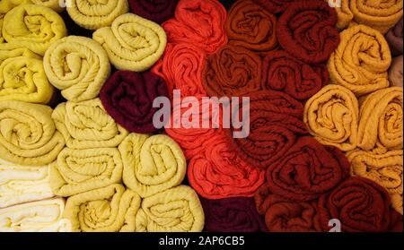 View on stack of rolled cloths in different colors on French market - Provence, France Stock Photo