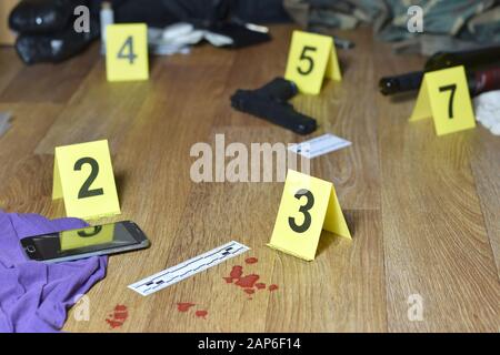 Id tents at crime scene after gunfight indoors. Blood and gun cartridges as evidence on crime scene investigation process close up Stock Photo