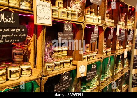 Roussillon (Provence), France - October 2. 2019: View on shelf made by wooden wine cases inside French shop with typical products. Glass jars with per Stock Photo