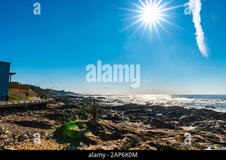 Porto Homem do Leme Beach Picturesque View with Walking People and Sun Rays on a Sunny Blue Sky Day Stock Photo