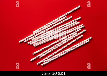 Paper straws with hearts on red background. Stock Photo