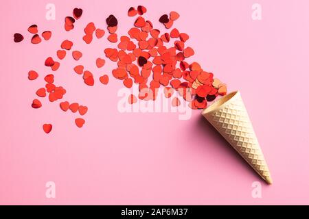 Red hearts and ice cream cone on pink background. Top view. Stock Photo