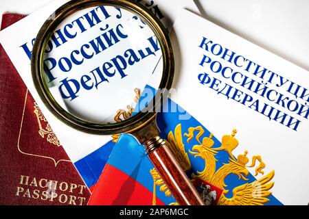Brochure "Constitution of the Russian Federation" under a magnifying glass with a Russian passport on a white background Stock Photo
