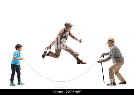 Full length profile shot of a grandfather and grandson holding a rope and an elderly man skipping isolated on white background Stock Photo