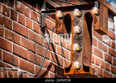 Rusty T-Sign on a red brick wall background Stock Photo