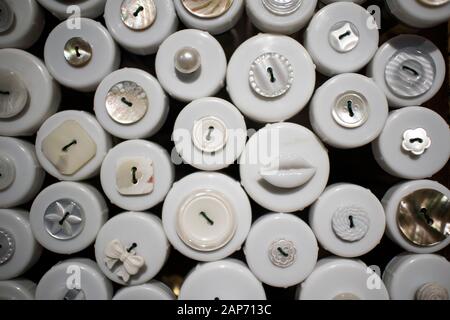 Multi-colored buttons in wooden boxes for sale in a store. Stock Photo