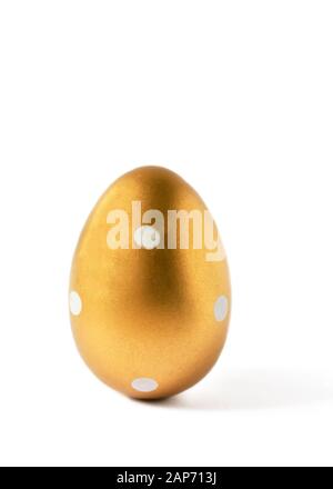 Golden colored easter egg isolated on white background. Modern easter egg painted in a fashion golden color. Happy Easter time. Stock Photo