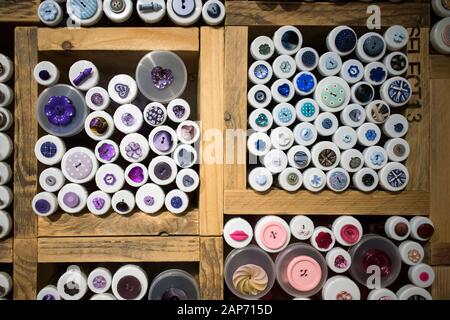 Multi-colored buttons in wooden boxes for sale in a store. Stock Photo