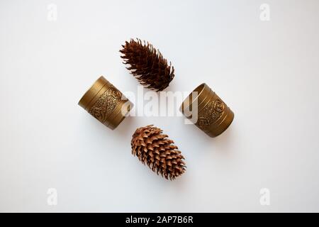Glossy golden candle holders and pine cones isolated on white background from a high angle view Stock Photo