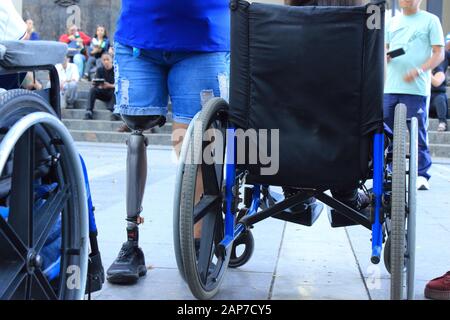 Disable people with prosthetic leg close to wheelchairs gather in public space Stock Photo