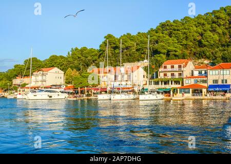 Boats docked in the small harbor at a picturesque fishing village along the Dalmatian Coast of Croatia near the city of Hvar on a sunny day. Stock Photo