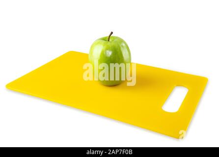 Green Apple on Yellow Cutting Board White Background Stock Photo
