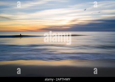 Surfer longboarding on a glassy wave. Slow Motion, blurred in Southern California, USA. Stock Photo