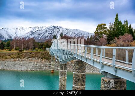 The stunning pedestrian footbridge over he amazing vivid blue water in Scott Pond at Lake Tekapo Stock Photo