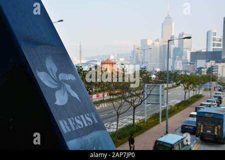 Protest graffiti painted on a pedestrian overpass with the skyline in the background in the Central District of Hong Kong. Stock Photo