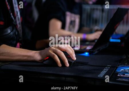 MOSCOW - DECEMBER 23 2019: esports Counter-Strike: Global Offensive event. Close up of hand over Game Mouse at gaming event. Gamer playing on a laptop Stock Photo