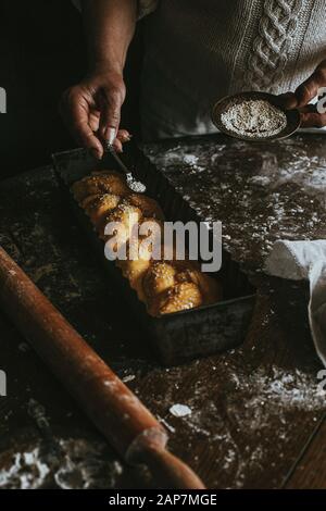 A Woman Prepares Homemade Braided Bread at Home Stock Photo