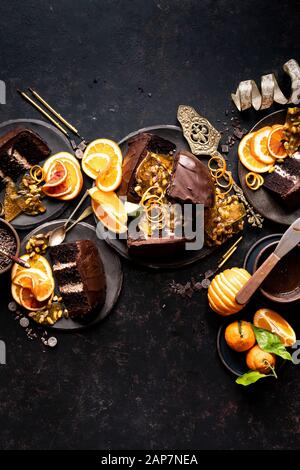 An Epic Gluten-free Chocolate Cake with ricotta cheese filling, chocolate frosting, chocolate glaze, orange slices and pistachio praline served with c Stock Photo