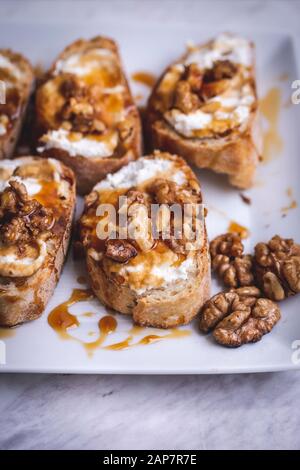 Trray with ricotta, honey and walnuts crostini Stock Photo
