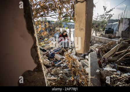 Gaza City, Palestine. 19th Jan, 2020. Toto Hammouda Abu Amra, 15, writes her homework from the ruins of her family's destroyed home.The Abu Umrah family that consists of 19 individuals lost their five-storied house after an Israeli raid on Gaza on November 13, 2019. Credit: SOPA Images Limited/Alamy Live News Stock Photo