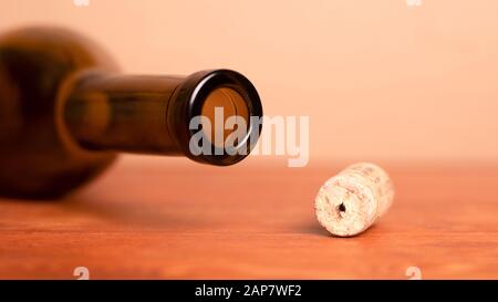 Wine cork and lying empty  bottle  on the table. Stock Photo