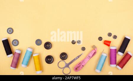 flat lay  Sewing kit accessory or tailor tool workshop .Space for creative design mock up frame. threads, pins, scissors, buttons. Stock Photo