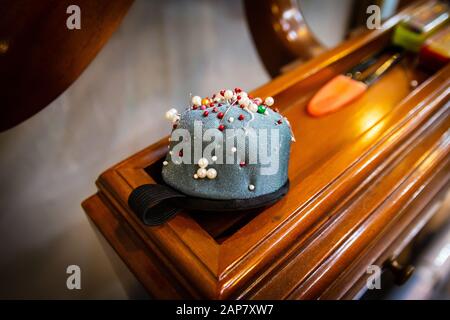 gray pincushion with several color pins Stock Photo