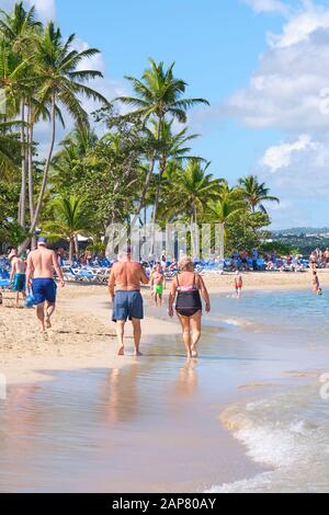 Vacationers enjoy the beach and surf of Playa Dorado near Puerto Plata Dominican Republic. Stock Photo