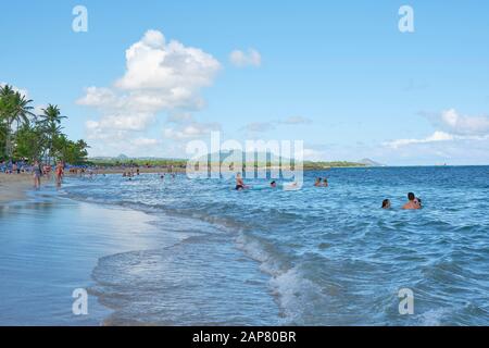 Vacationers enjoy the beach and surf of Playa Dorado near Puerto Plata Dominican Republic. Stock Photo