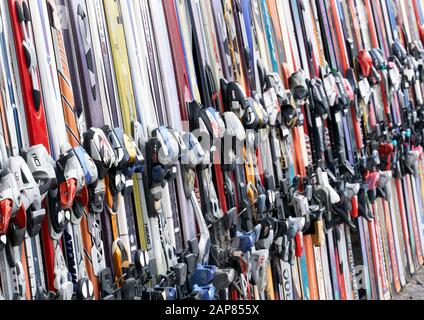 Montreal, Canada - December 23, 2019: Alpine downhill skis of different brands such as Atomic, Rossignoli, Fischer etc standing against a wall at a sk Stock Photo