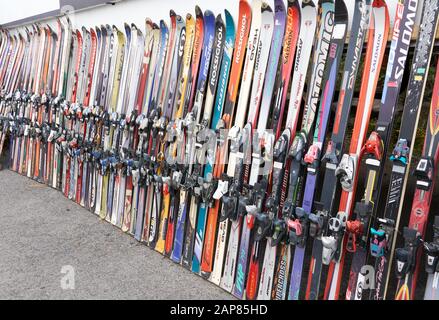 Montreal, Canada - December 23, 2019: Alpine downhill skis of different brands such as Atomic, Rossignoli, Fischer etc standing against a wall at a sk Stock Photo