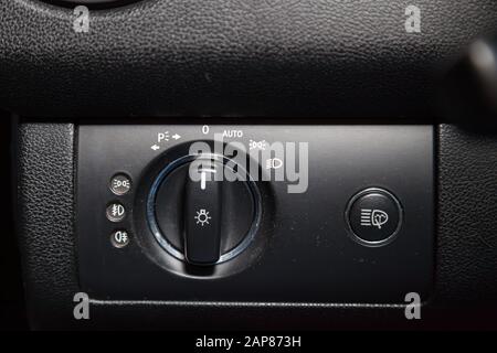 Close-up on the headlight switch control buttons and automatic adjust level dashboard in car in the back of a suv after cleaning and detailing in the Stock Photo