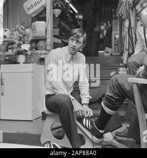 Johan Cruijff in his sports store Description: Cruyff helps a customer fit a shoe Date: 8 August 1968 Location: Amsterdam, Noord-Holland Keywords: portraits, sports affairs Personal name: Cruyff, Johan Stock Photo