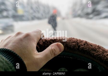 Emergency. A man's hand on the steering wheel of a car while braking against the background of a pedestrian suddenly appearing Stock Photo