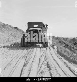 construction and improvement of roads, dikes and savings basins, cement stabilization, sand bed, trucks Date: July 1957 Location: Schouwen-Duiveland, Zeeland Keywords: construction and improvement of roads, cement stabilization, dikes and savings basins, trucks, sandbed Stock Photo