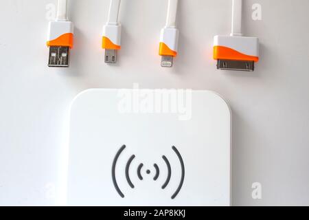Cables recharger Lightning to USB Cable, 30-pin to USB, Micro USB and a wireless charger. Stock Photo