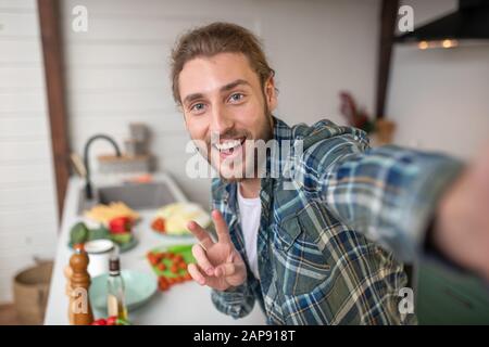 Smiling man making selfie on his kitchen Stock Photo