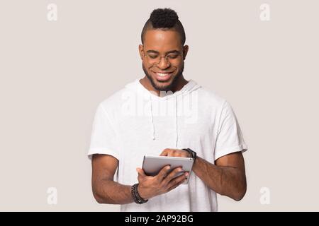 Happy black man using tablet shopping online in studio Stock Photo