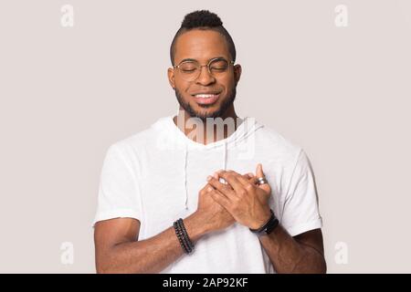 Grateful black man hold hands at chest feeling thankful Stock Photo