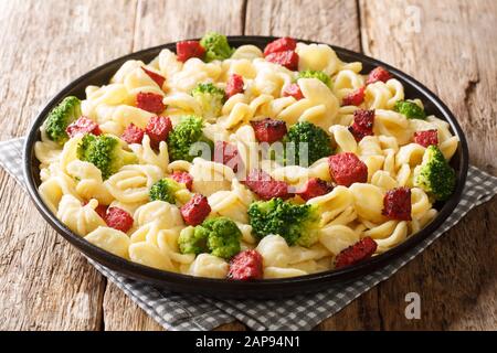 Serving of orecchiette pasta with broccoli and fried Italian sausages close-up in a plate on the table. horizontal Stock Photo